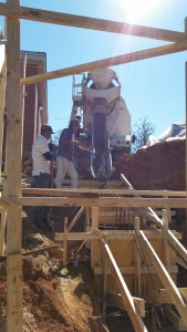 Workers direct the concrete into the forms for the foundation's footings. Photo: J.Galler.